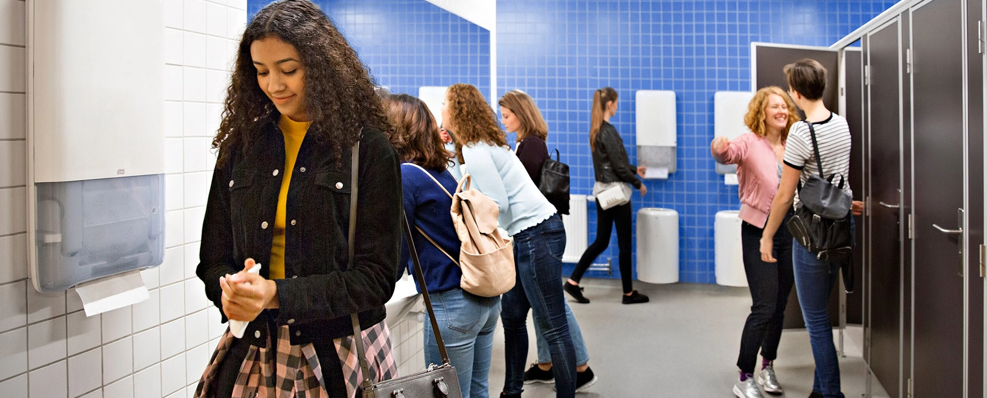 Women in public restroom using hand towels