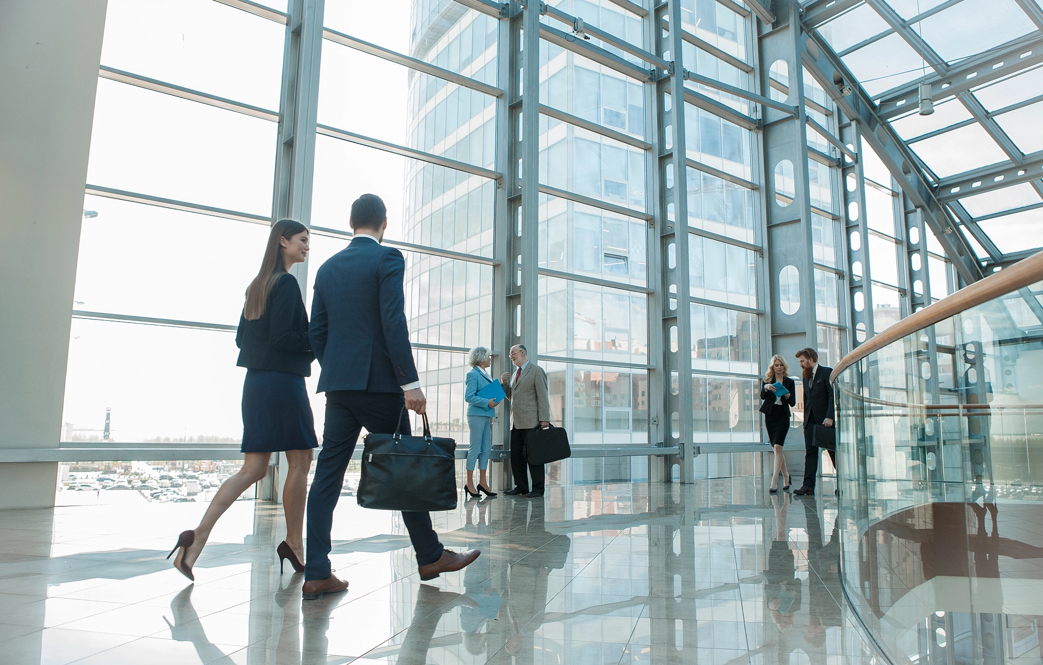 People dressed in business attire walking through an office lobby